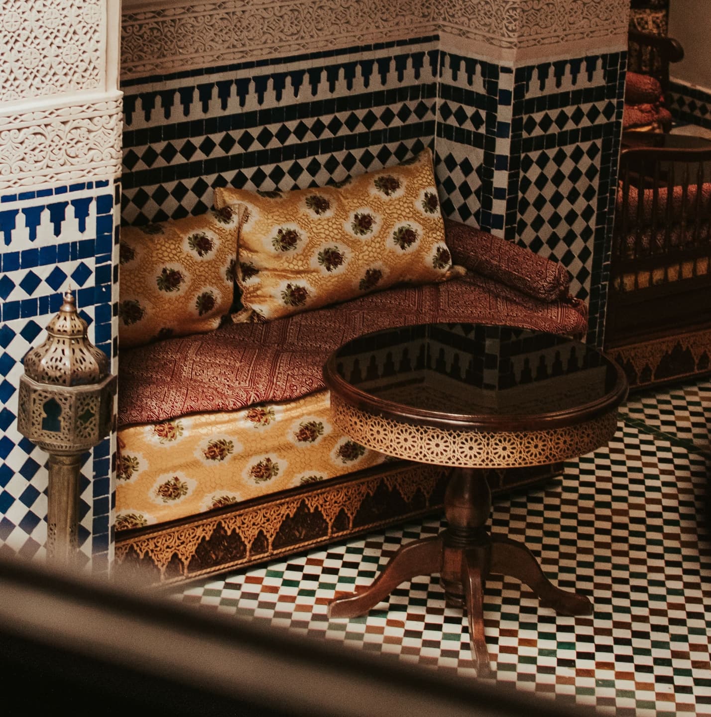 Ornate Moroccan riad lounge with cushions and mosaic tiles
